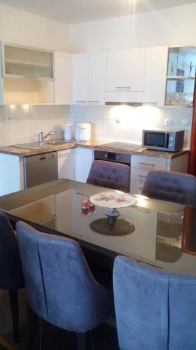 a kitchen with a table and some blue chairs at APARTMAN MATKOVIĆ in Imotski