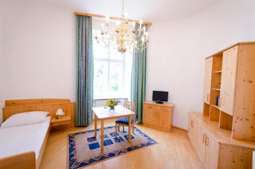 a bedroom with a table and a bed and a window at Schloss Gumpoldskirchen in Gumpoldskirchen