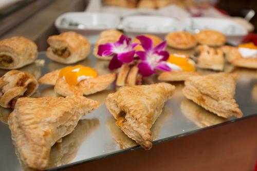 a tray of pastries on a table with flowers at Ascott Palace Dhaka in Dhaka
