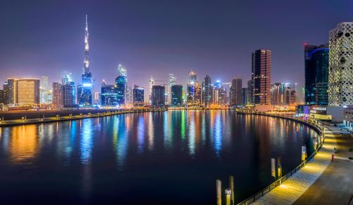 a view of a city skyline at night at Canal Central Hotel Business Bay in Dubai