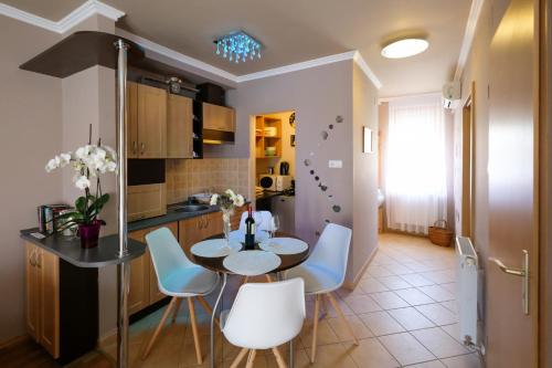 cocina y comedor con mesa y sillas en Novák Apartman, en Gyula