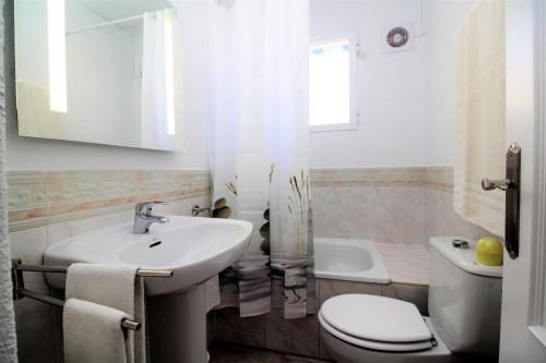 ein weißes Bad mit einem Waschbecken und einem WC in der Unterkunft Villa Mediterránea in L’Alfàs del Pi
