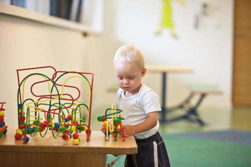 a young boy playing with toys on a table at Hotel Grüner Baum in Bressanone