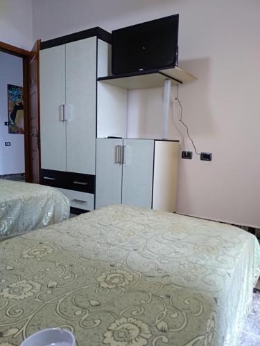 a room with two beds and white cabinets at Hotel Gjeli in Fier