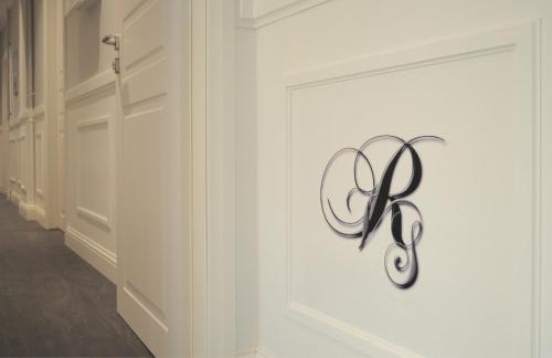 a white wall with a metal sign on it at Residenza Vatican Suite in Rome
