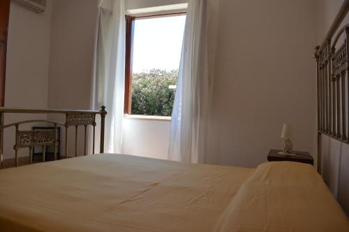 a bedroom with a large bed and a window at Angelo Holiday Home in Valderice