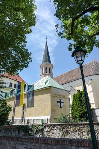 a church with a steeple and a street light at Schloss Gumpoldskirchen in Gumpoldskirchen