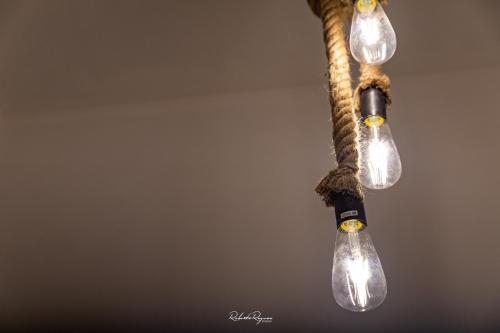a group of light bulbs hanging from a pole at Sweet Roma 315 in Palermo