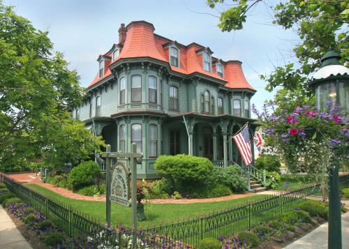 a large house with an american flag in front of it at The Queen Victoria in Cape May