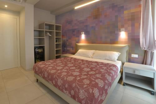a bedroom with a bed with a brick wall at Hotel Villa MIKI in Bordighera