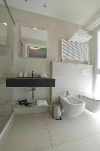 a bathroom with a sink and a toilet and a mirror at Hotel Villa MIKI in Bordighera