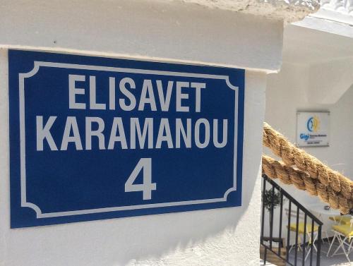 a blue sign on the side of a building at Gigi Rooms in Poros