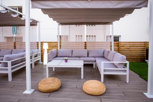 a patio with a couch and a table and chairs at We Hostel Palma - Albergue Turístico in Palma de Mallorca