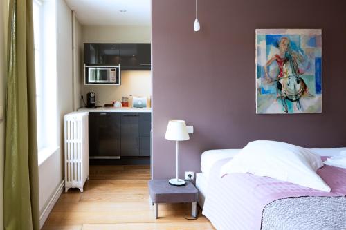 a bedroom with a bed and a painting on the wall at Maison d'Hôte de Myon in Nancy
