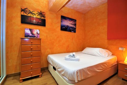 ベニドルムにあるLas Palmas 2-10のベッドルーム1室(ベッド1台、ドレッサー、写真付)