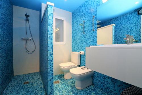 y baño azul con aseo y ducha. en Las Palmas 2-10, en Benidorm