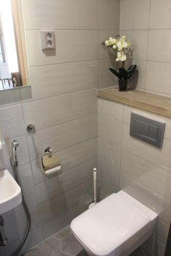 a bathroom with a toilet and a vase of flowers at Naava Chalet Pikku Panda (305) in Ähtäri