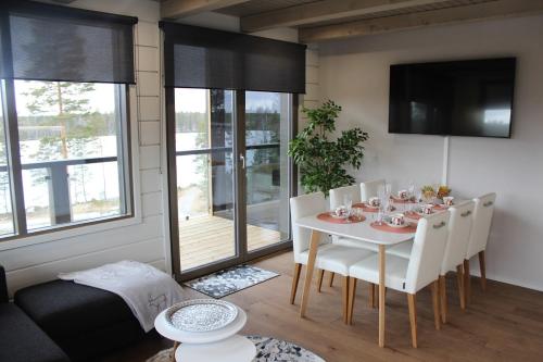 uma sala de jantar com uma mesa branca e cadeiras brancas em Naava Chalet Pikku Panda (305) em Ahtari