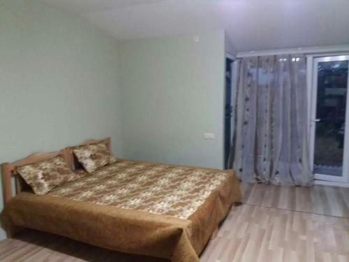 a bedroom with a bed and a large window at Guest House TiAni in Kobuleti