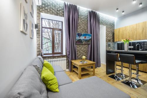 a living room with a couch and a kitchen at Pushkinskaya Apartments in Kyiv