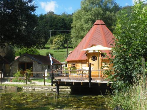 a house with a red roof on the water at kotas-Esprit Nordique in Balaives-et-Butz