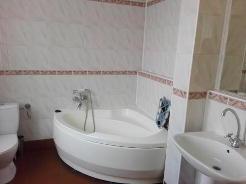 a bathroom with a tub and a toilet and a sink at Bristol Economy in Bytom