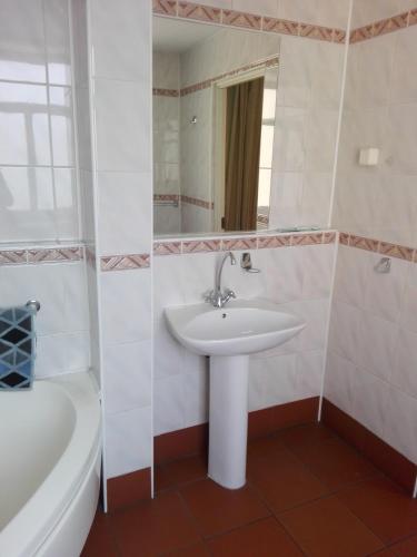 a bathroom with a sink and a tub and a mirror at Bristol Economy in Bytom