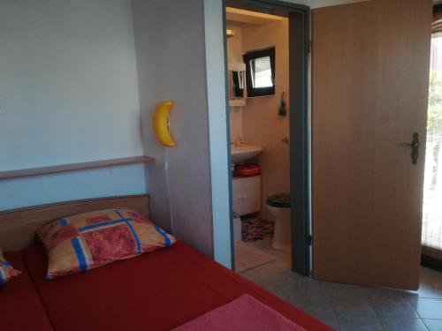 a small bedroom with a bed and a bathroom at Apartmani Parlov in Vinišće