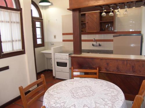 Una cocina con una mesa, un fregadero y una estufa. en La Alhambra Apart Hotel, en Florianópolis