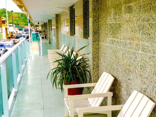 a row of chairs and a plant on a balcony at Thermas Hotel in Salgadinho
