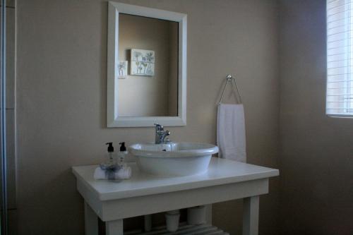 a bathroom with a white sink and a mirror at 113 on Robberg in Plettenberg Bay
