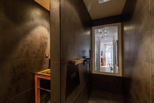 ein Bad mit einem Wandspiegel in der Unterkunft Veeve - Museum Marvel in Paris