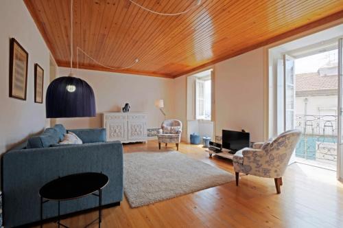a living room with a blue couch and chairs at Portas do Teatro Apartments in Lisbon