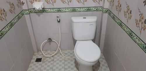 La salle de bains est pourvue de toilettes blanches avec un tuyau. dans l'établissement Wahyu Homestay 2, à Nusa Lembongan