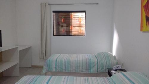 a white room with a bed and a window at Thermas Hotel in Salgadinho