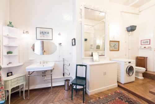 une salle de bain avec un lavabo, des toilettes et un miroir dans l'établissement Veeve - Antique Charm by Arc de Triomphe, à Paris