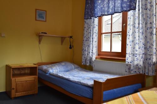 a small bedroom with a bed and a window at Penzion Bělidlo in Kunžak