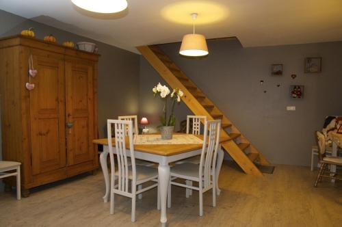 Au Coeur d'Alsace Chambres d'hôtes في كينتزهيم: غرفة طعام مع طاولة وكراسي ودرج