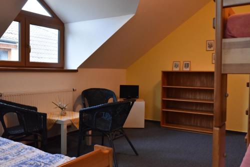 a dorm room with a bed and a desk and chairs at Penzion Bělidlo in Kunžak