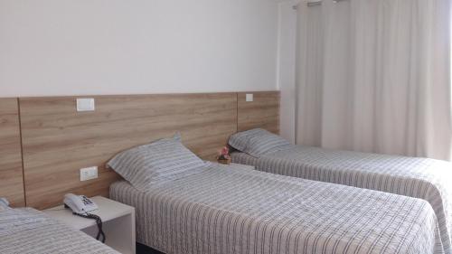 a room with two beds and a phone on a table at Thermas Hotel in Salgadinho