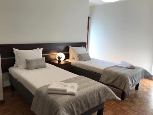 um quarto de hotel com duas camas com toalhas em Casa de Lencastre em Viana do Castelo