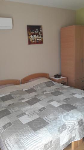 a bedroom with a bed with a quilt on it at Apartmani V&F in Vrnjačka Banja