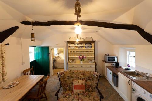 uma cozinha com uma mesa e uma sala de jantar em Cissy's Cottage em Aghanloo