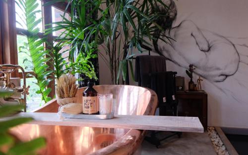 a table with a bottle of wine on top of it at Artistic and Quirky Home with a Copper Bath and Complimentary Snack in Bangkok