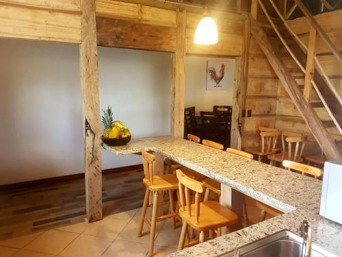 Una cocina con barra con taburetes de madera. en Casa El Granero Monteverde, en Monteverde