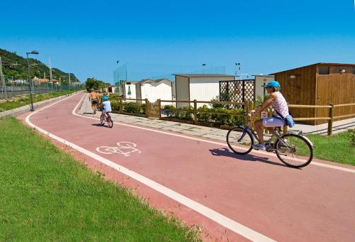a woman and a child riding a bike on a road at Hotel Ristorante Miramare in Pesaro
