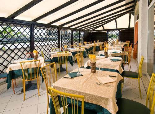 a dining room with tables and chairs in a restaurant at Hotel Ristorante Miramare in Pesaro