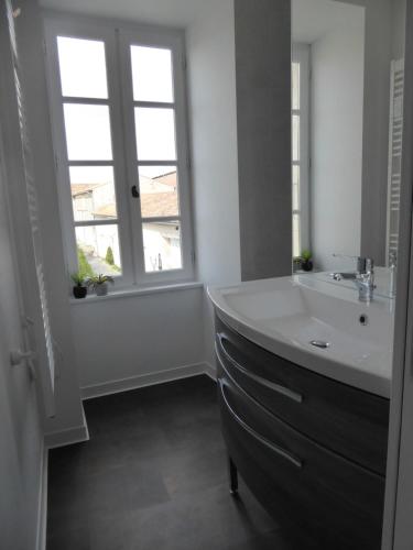 une salle de bain avec un lavabo et une grande fenêtre dans l'établissement Chateau d'Annezay, à Annezay