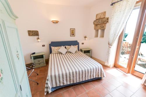 sypialnia z łóżkiem w pokoju z oknami w obiekcie Masseria Ruri Pulcra w mieście Patù