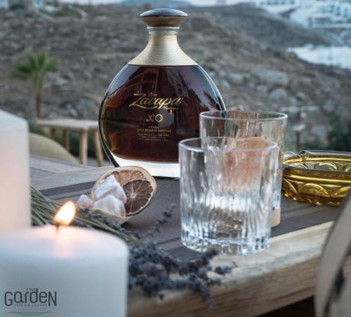 una bottiglia di vino e un bicchiere su un tavolo con una candela di Legacy Suites a Mykonos Città